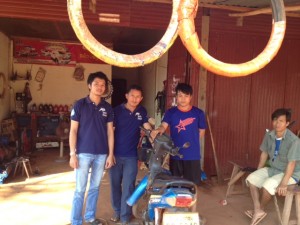 Mr. S with Peuan Mit staff at his garage business in Kham Noi village.